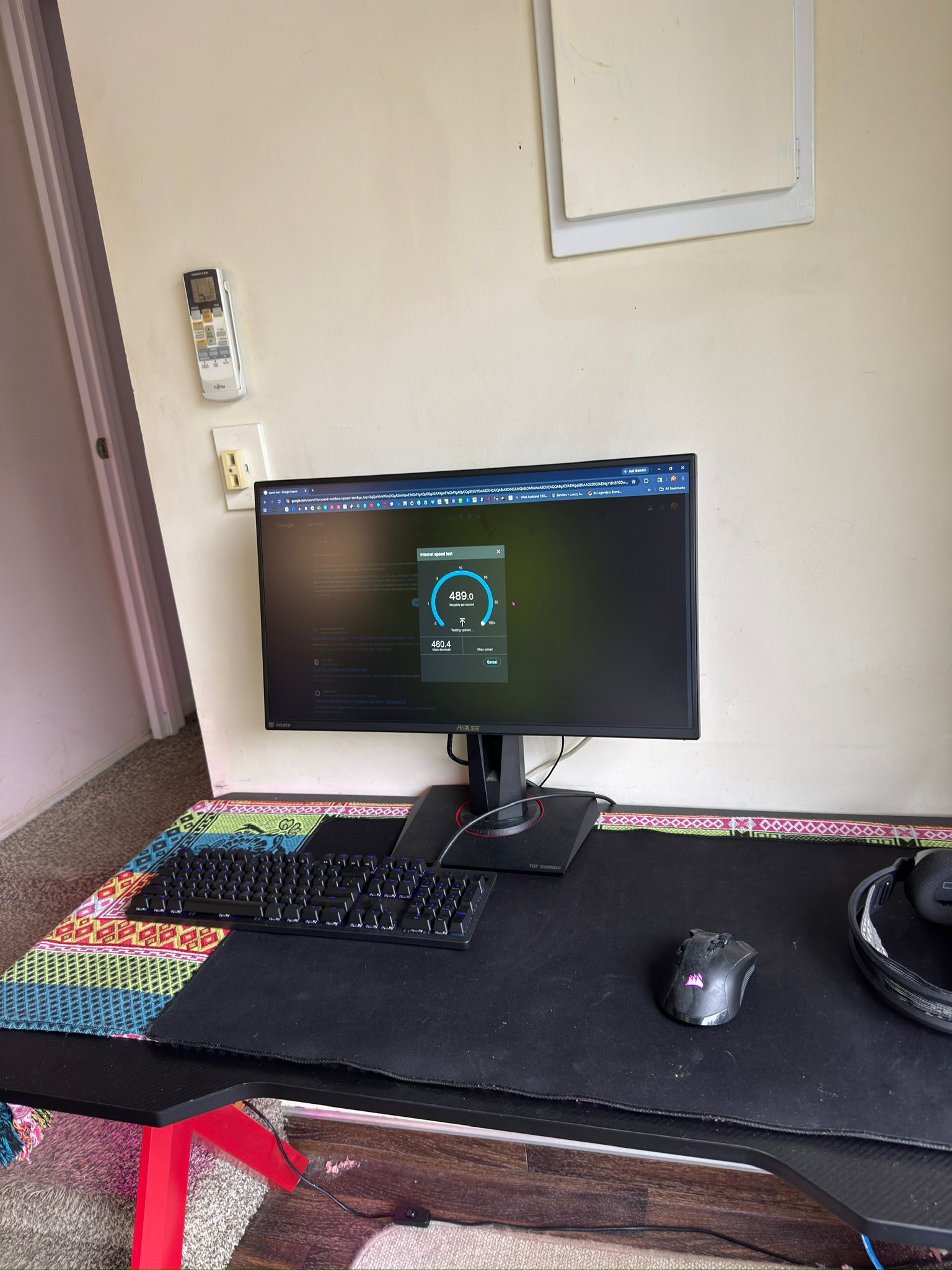 Tom's gaming desktop in his Ranui garage showing a Google internet speed test result of 489 Mbps download and 460 Mbps upload